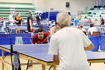Joueurs de tennis de table autour d'une table en train de jouer.